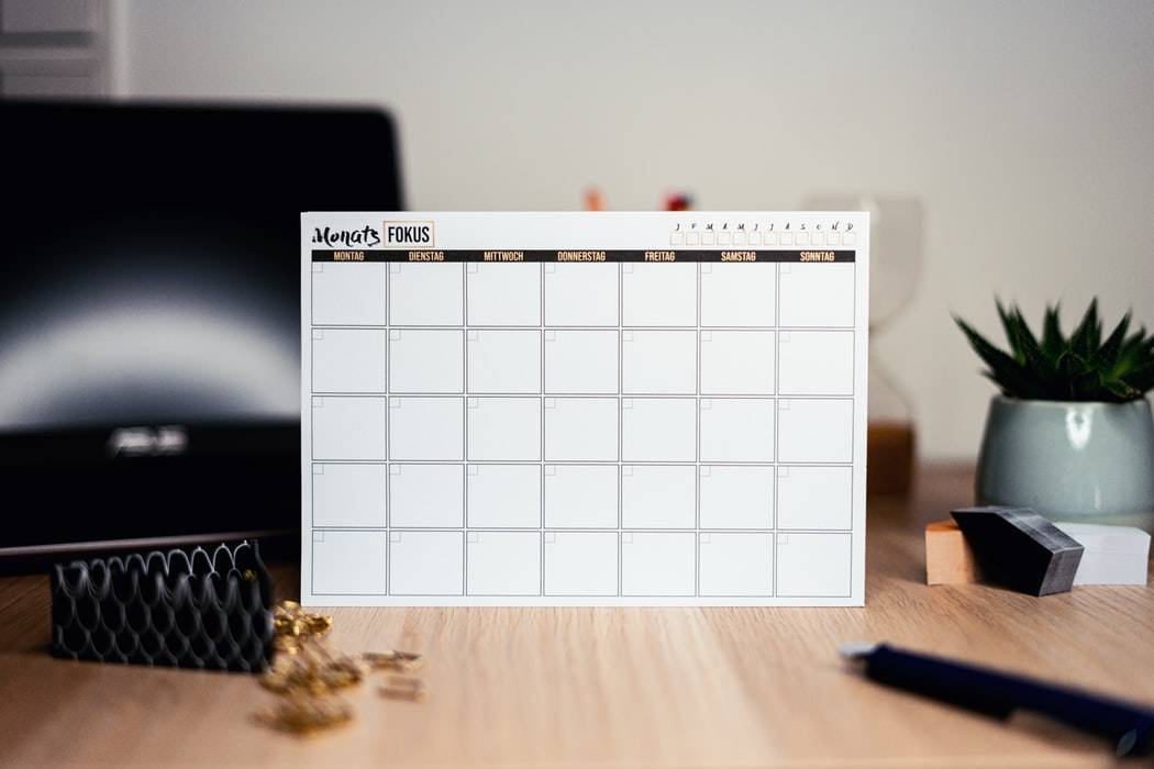 Deskpad calendar on a desk with stationery
